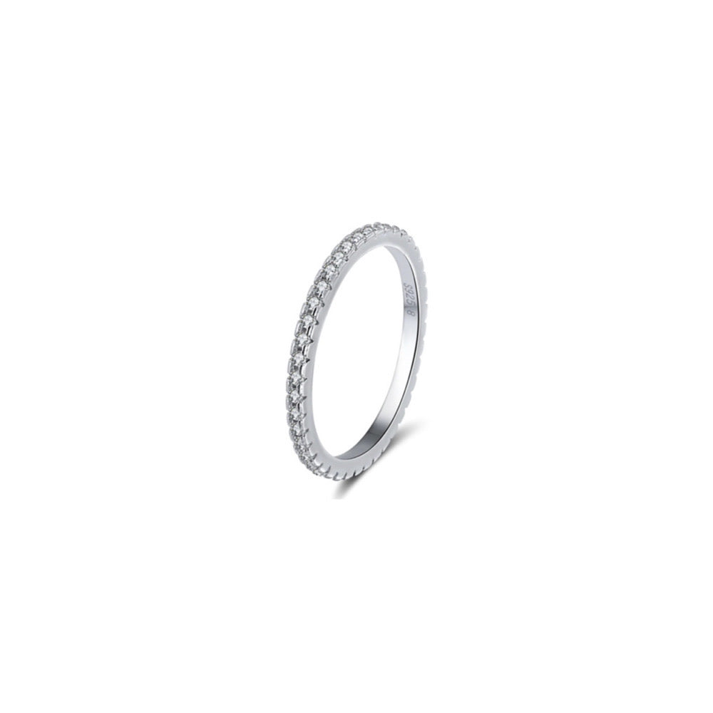 Sterling silver eternity band ring with 37 small cubic zirconia stones, rhodium-plated. Pictured at a 45 degree angle, with white background.