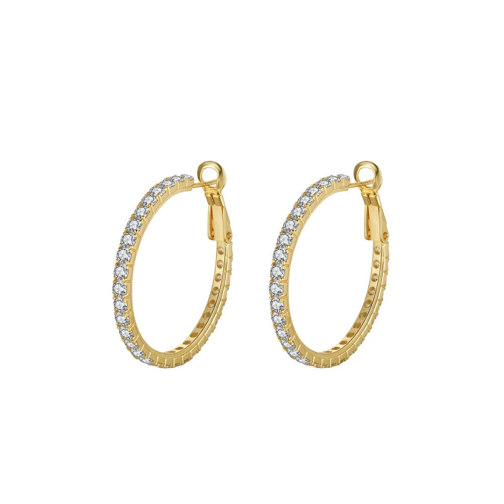 Earring hoops made of sterling silver with cubic zirconia stones. 14K gold-plated. Pictured at a 45 degree angle with white background.